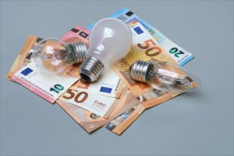 Banknotes and light bulbs, electricity costs