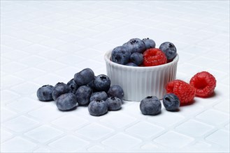 Blueberries in small bowls, raspberries