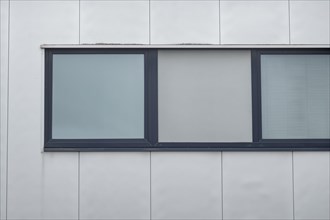 Large window on a modern building facade with blue window sills