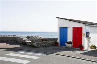 Garage painted in French national colours by the sea, Guilvinec, Finistere, Brittany, France,
