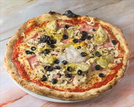 Capricciosa pizza with cheese, bacon, tomatoes, mushrooms and basil, italian meal. Baked neapolitan