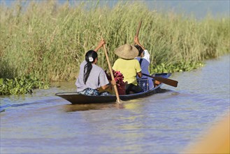 Two people paddling in a traditional canoe, Inle Lake, Myanmar, Asia