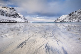 Sandy beach beach with snow-covered mountains, Ersfjorden beach, Senja Island, Norway, Europe