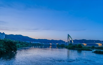 Modern bridge over a river captured during the blue hour, in South Korea