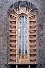 High Gothic church window surrounded by red bricks