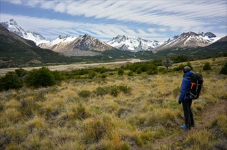 Hiker enjoying the view of the mountains and glaciers of the Patagonian Andes with Monte San