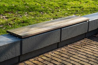 Modern wooden bench on a concrete foundation in the outdoor area