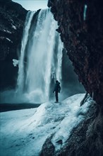 Photographer woman in winter in Iceland visiting Skogafoss waterfall