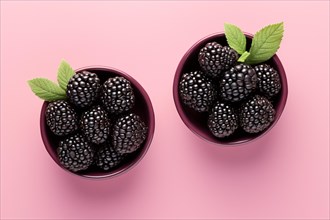 Top view of two small bowls with blackberry fruits on pink background. KI generiert, generiert AI