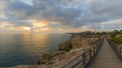 Wooden walkway along the rocky coast in the Algarve, travel, holiday, sunset, evening mood,