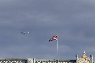 Airbus A380 aircraft of Emirates airlines in flight with a Union Jack flag on Tower Bridge in the