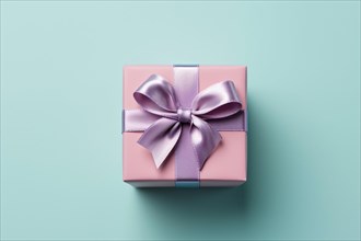 Top view of pink gift box with purple silk ribbon on blue background. KI generiert, generiert AI