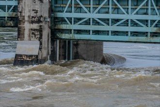 Closeup of dam with water surging through open floodgates after torrential monsoon rains in Daejeon