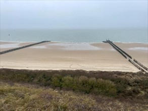 View of a quiet beach with breakwaters in the grey daylight, Westkapelle, Zeeland, Netherlands