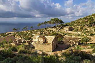 Stone houses nestled among pine trees with a sea view in a tranquil Mediterranean setting, Hiking