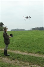 Hunter observes and controls flying drone during a hare (Lepus europaeus) census, Lower Austria,