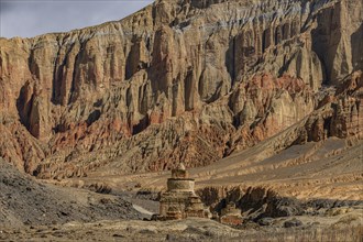 Colourfully painted Buddhist stupa, before a colourful eroded mountain scenery, Kingdom of Mustang,