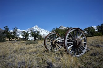 Old wooden cart in front of the snow-covered Monte San Lorenzo, Perito Moreno National Park,