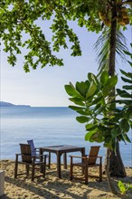 Seat with table and chairs at Maenam beach on Koh Samui, island, palm tree, water travel, holiday,