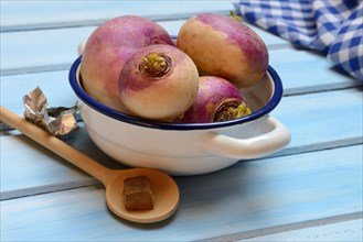 Purple turnips in pot and cooking spoon with stock cube, Brassica rapa
