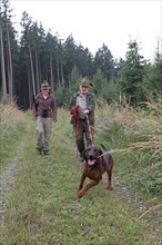 Huntsman and huntress, accompanied by hunting dog Bavarian Mountain Hound, Allgaeu, Bavaria,