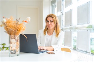 Portrait of a female beauty real estate agent using laptop in her office