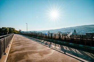 Morning atmosphere on an empty bridge with a view of the city in the warm sunlight, cycle path,