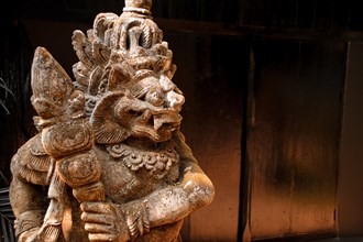 A weathered stone statue of a thai mythological creature, showcasing intricate carvings. Chiang