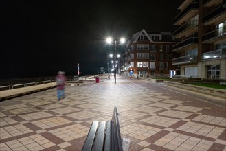 Illuminated promenade at night with a walker, DeHaan, Flanders, Belgium, Europe