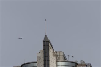 Airbus A319-100 aircraft of British airways in flight over a city skyscraper building, London,