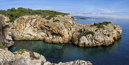 Wide view of rugged rock formations along a serene Mediterranean coastline, Coastal Hiking tour in