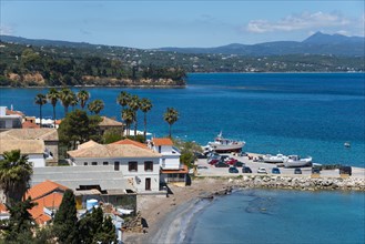 View of a quiet coastal landscape with beach, boats and houses, harbour and old town, Koroni,