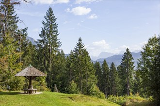Karwendel mountains with forest and shelter with benches, in autumn, hiking trail Kramerplateauweg,