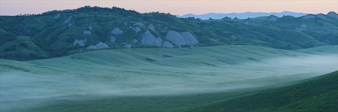 Early morning fog shortly in front of sunrise in the Crete Senesi, Province of Siena, Tuscany,