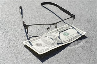 Banknote of Ten Dollar and Eyeglasses with Sunlight in Switzerland