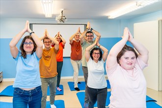 Disabled group of people practicing yoga together in a gym with good vibes