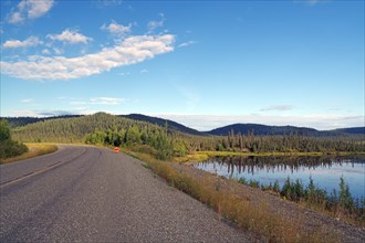 Traffic-free road leads through tranquil lakes and forests, late summer, Alaska Highway, Yukon