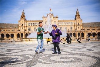 Seville, Spain, March 9, 2022: dancing people in front of the fountain in Plaza de Espana, Seville,