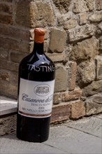 Giant wine bottle as an advertisement and invitation to a wine tasting in front of a wine shop,
