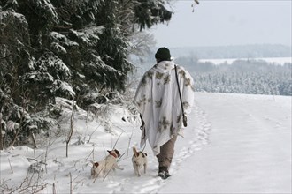 Hunter in winter with snow shirt and Jack Russell Terrier, Allgaeu, Bavaria, Germany, Europe