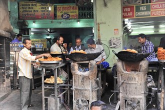 People buying food at a street stall selling freshly prepared food, Varanasi, Uttar Pradesh, India,