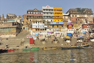 Human life and colourful architecture at the ghats on a busy river, Varanasi, Uttar Pradesh, India,
