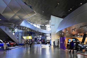 Large exhibition hall with modern vehicles and interactive displays, BMW WELT, Munich, Germany,