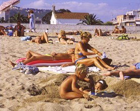 Sunbathers and playing children on the beach in Calella, Costa Brava, Barselona, Catalonia, Spain,