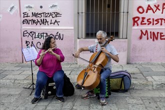 Oaxaca, Mexico, A man and a woman play classical music on the bass and flute. They are playing for