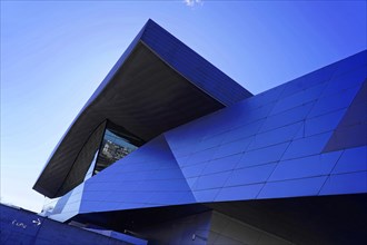 Modern building architecture with a blue facade under a clear sky, BMW WELT, Munich, Germany,