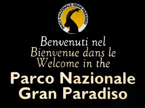 Wooden welcoming board with logo of the Gran Paradiso National Park in the Graian Alps, Italy,