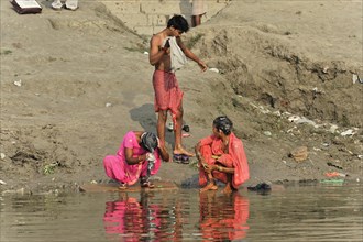 Children and adults washing themselves and their clothes in a river, Varanasi, Uttar Pradesh,