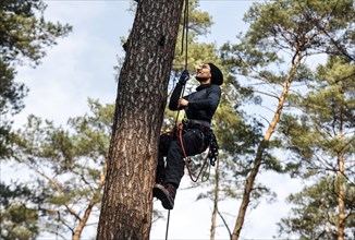 An activist pulls himself up a rope to one of the tree houses in the Gruenheide forest. The