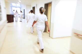 Nurses and care staff walk across a corridor in a clinic in Berlin, 25/01/2019